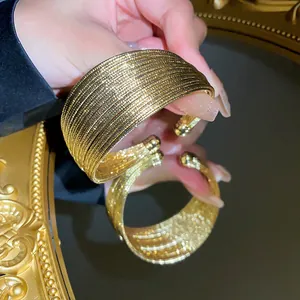 Detailed close-up of a luxury gold-plated multi-layer open cuff bracelet for women