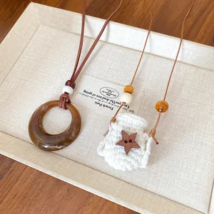 Detailed view of vintage Maillard acrylic ring and knitted star bag necklaces