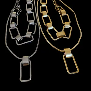 Vista dettagliata di collane geometriche a maglie rettangolari in oro e argento.