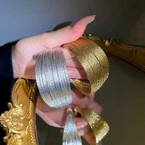 Detailed view of textured gold and silver multi-layer open bangles with high-end shine