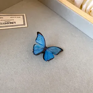 Primer plano de un dije de mariposa azul vibrante con texturas de alas realistas para pulsera