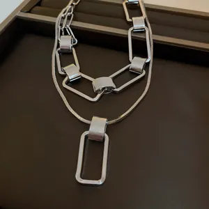 Primo piano di una collana a doppio strato argento con maglie rettangolari