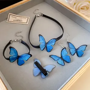Vista detallada del conjunto de joyas de mariposa azul con collar, pulsera y pendientes