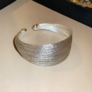 Close-up of elegant multi-layer silver-plated open cuff bracelet with metallic luster