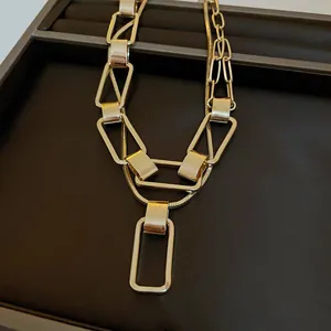 Dettaglio di una collana a maglie rettangolari dorate su un espositore di gioielli