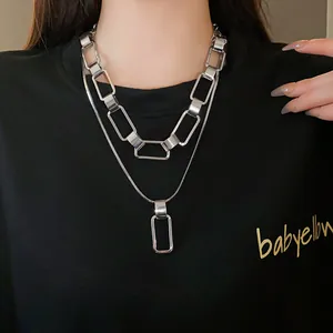 Primo piano di una collana a doppio strato argentata con pendente rettangolare