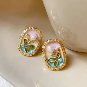 Detailed view of elegant vintage floral enamel stud earrings with pearls and sparkling rhinestones