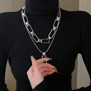 Dettaglio di una collana a doppio strato in argento con maglie geometriche rettangolari
