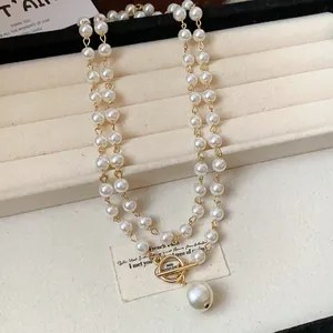 Dettaglio della collana di perle retrò francese con chiusura OT dorata e pendente.