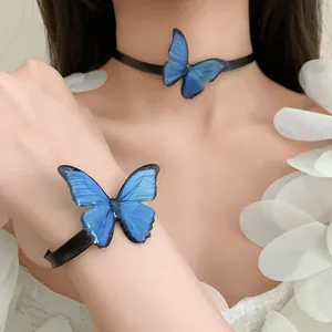 Detalle de primer plano del conjunto de gargantilla y pulsera de mariposa azul