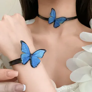 Primer plano de un conjunto de gargantilla y pulsera de mariposa azul en una bella modelo