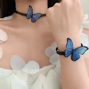 Vista detallada de una gargantilla de mariposa azul y pulsera a juego en una modelo.