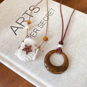 Detail view of Maillard style acrylic ring and crochet star pouch pendant necklace