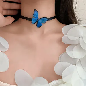 Detalle de una elegante gargantilla de mariposa azul con correa tejida negra fina