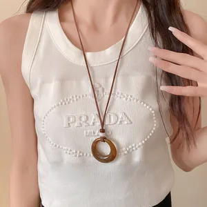 Close-up of retro acrylic round hollow pendant necklace in Maillard style worn on model