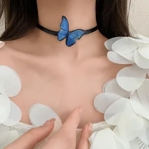 Primer plano de un collar choker de mariposa azul artístico en una modelo con pétalos