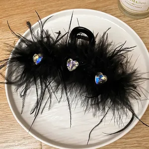 Elegant black feather hair claw clip with sparkly rhinestone heart details for women
