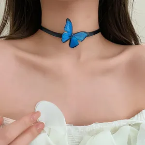 Vista detallada de una elegante gargantilla de mariposa azul en el cuello de modelo