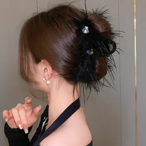 Close-up detail of a heart rhinestone feather hair claw clip on a model's styled bun.