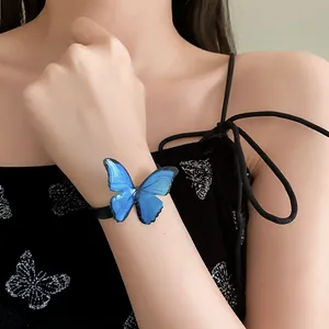Detalle de primer plano de una mariposa azul realista en una pulsera tejida negra.