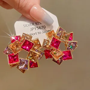 Primo piano di orecchini a fiori in cristallo quadrato con aghi in argento 925.