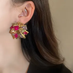 Dettaglio ravvicinato di un orecchino floreale con cristalli quadrati multicolori.