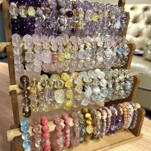 Detailed display of colorful glass beaded bracelets with floral charms on a wooden stand