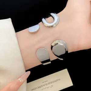 Close-up detail of silver metal teardrop open cuff bracelet with high-polish finish