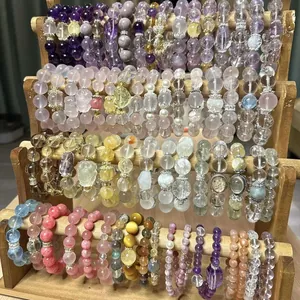 Detailed macro view of various colorful beaded bracelets on a tiered wooden display stand