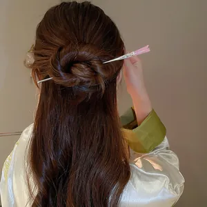 Vue détaillée d'un élégant pic à cheveux tulipe rose dans un chignon classique