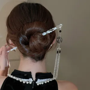 Pic à cheveux élégant de style chinois avec glands porté dans un chignon classique.