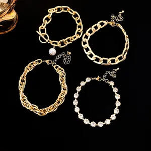 Close-up of four gold hip-hop bracelet set with pearl and rhinestone details