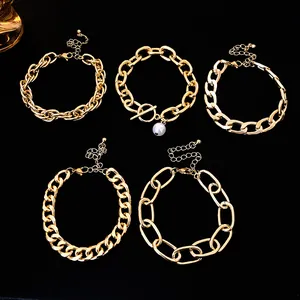 Close-up detail of five chunky gold chain bracelets showcasing trendy hip-hop layered styles