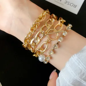 Close-up of multi-layer gold chain bracelet set with rhinestones and pearl charm