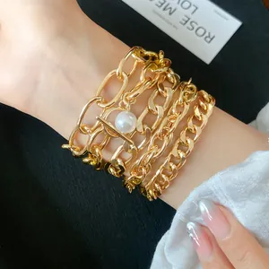 Exquisite multilayer gold-toned chain bracelet featuring a large pearl charm on a wrist