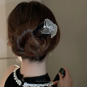 Détail d'une épingle à cheveux papillon argentée vintage avec pampilles en chignon