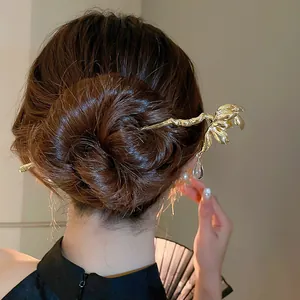 Épingle à cheveux élégante en or avec motif floral et pendentif gland dans un chignon