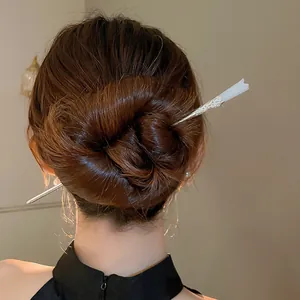 Pic à cheveux néo-chinois élégant avec détail de fleur blanche dans un chignon.