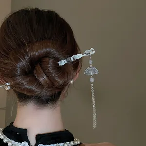 Détail exquis d'un pic à cheveux de style chinois avec gland en éventail sur un chignon