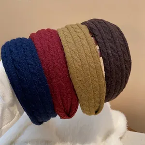 Detailed macro shot of knitted twist-pattern headbands in four different autumnal colors