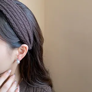 Detail view of a brown textured fabric headband worn for a high cranial top effect