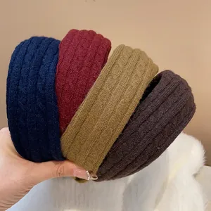 Close-up of four winter knit headbands in navy, red, olive, and brown colors.