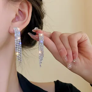 Detailed close-up showing sparkling silver rhinestone long tassel earrings worn on ear