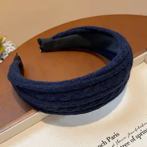 Close-up detail of a navy blue knitted fabric headband with a thick padded design