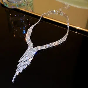 Detailed macro view of silver rhinestone V-shaped fringe necklace with sparkling gems