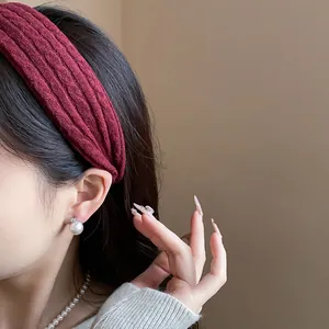 Detail view of a burgundy textured fabric headband for a stylish high skull top look