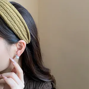 Close-up of a stylish mustard yellow knitted fabric headband worn by a model for a high top look