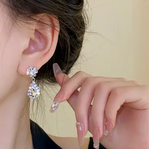 Elegant water-drop shaped rhinestone earrings showcased on a model's ear for detail.