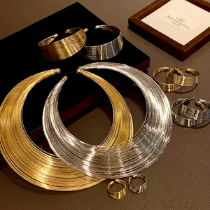 Close-up of multi-layer metal necklace and jewelry set in gold and silver finish