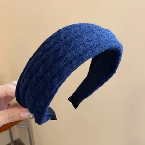 Close-up detail view of navy blue knitted fabric headband with elegant high-crown design